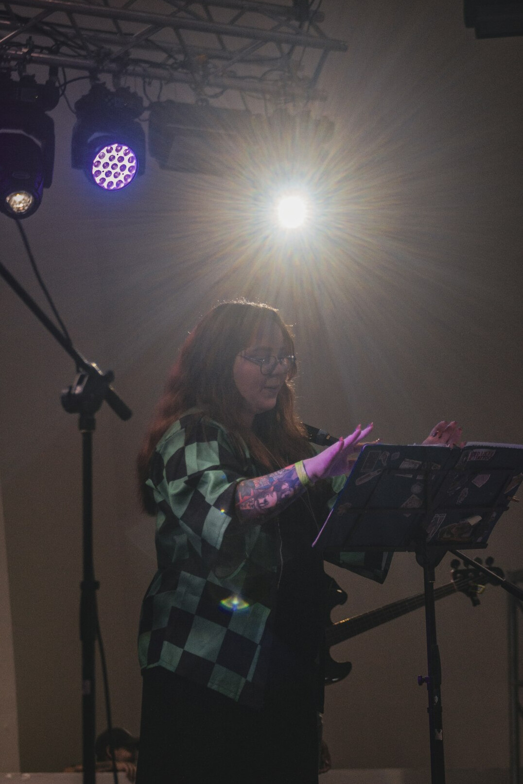 Latina pop singer performing with a microphone under stage lights