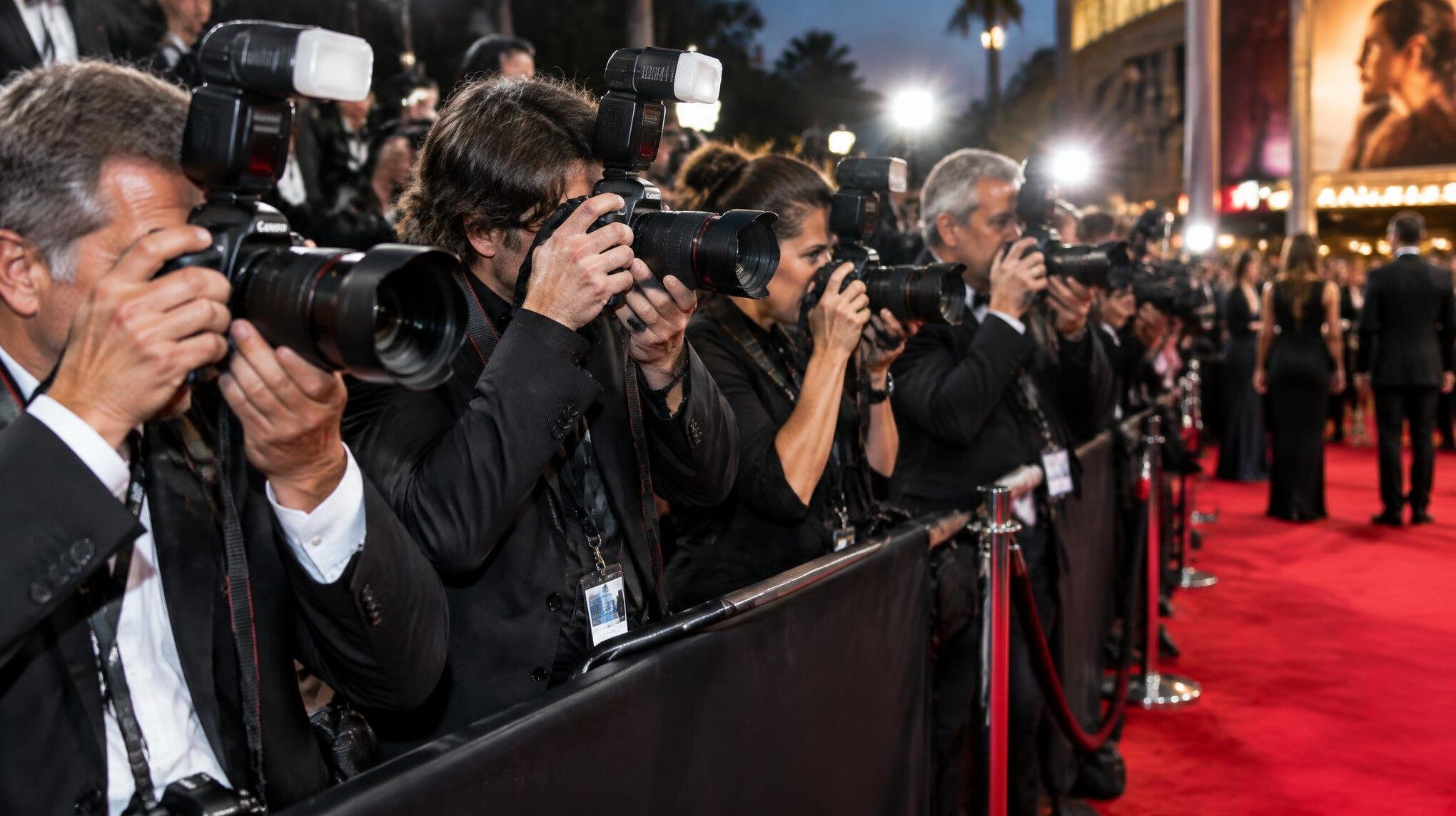 Row of photographers with cameras at a red carpet premiere